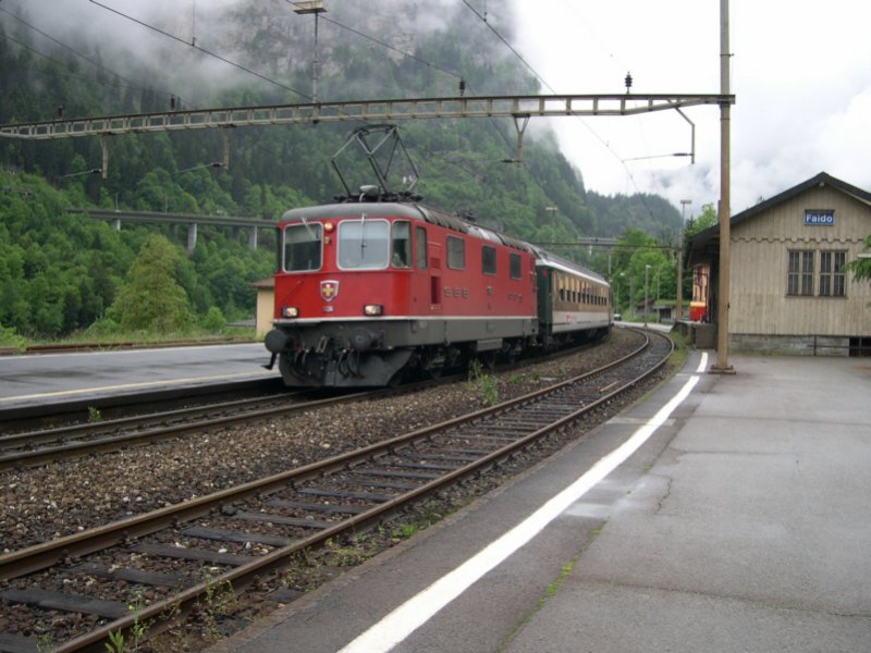 Gotthard 2008 - Mit IR 2259 ist am 22.05.2008 die Re 4/4 11126 an die italienische Grenze nach Chiasso unterwegs. Hier schleicht sie langsam durch den Bahnhof des kleinen Ortes Faido an der Gotthard-Sdrampe. Schlielich kurvt vor ihr noch der IR 2261 nach Locarno rum, den sie schon fast eingeholt hat. In Bellinzona kommen die Zge nur im Abstand von 4 min an.
