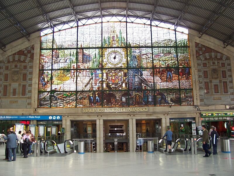 Groes Glasfenster mit Uhr im RENFE-Bahnhof Bilbao Abando, aufgenommen September 2005.