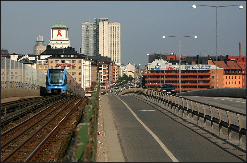 Grüne Linie, Skanstullbron - 

Im Anschluss an den Tunnel durch Södermalm steigt die Strecke auf der 1946 fertigestellten Skanstullbrücke bis zu einer Höhe von 32 Meter an. Die Brücke überquert die Hammarby-Schleuse. Von 1933 bis 1946 benützte die vorlaufende Straßenbahn die tieferliegende Skansbron, die für den Schiffsverkehr als Klappbrücke ausgeführt wurde. 

24.08.2007 (M)