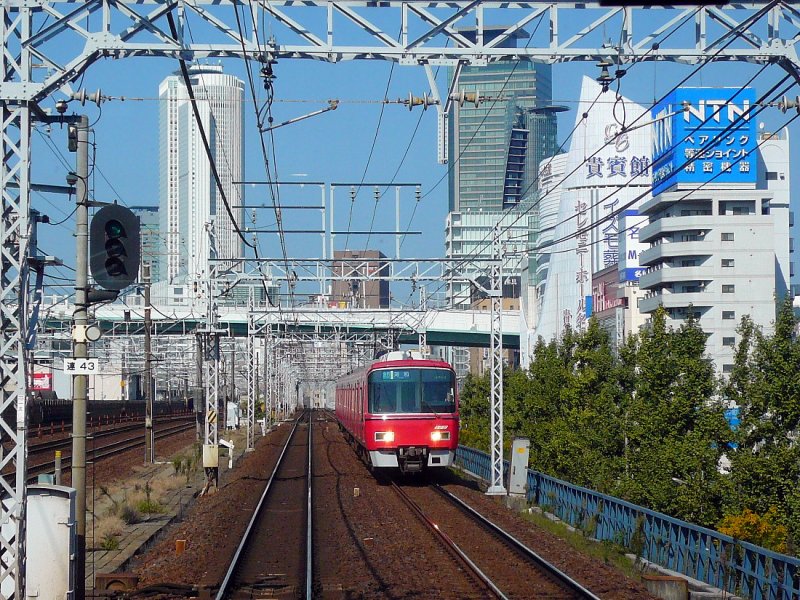Grunddaten des Meitetsu-Konzerns ( Meitetsu  bedeutet  Nagoya Eisenbahn ): Die S-Bahn des Ballungsraums Nagoya ist fast vollständig in der Hand des 1921 gegründeten Meitetsu-Konzerns mit heute über 200 Firmen und ca.450 km Bahnlinien. Betrieb mit Gleichstrom 1500 V. Mit 6 verschiedenen Zuggattungen besteht ein unglaublich komplexes Angebot. Hier ist ein Zug der Serie 3700 (1997/8 gebaut) beim Nagoya Hauptbahnhof mit seinen markanten Hochhäusern, 30.Oktober 2008.