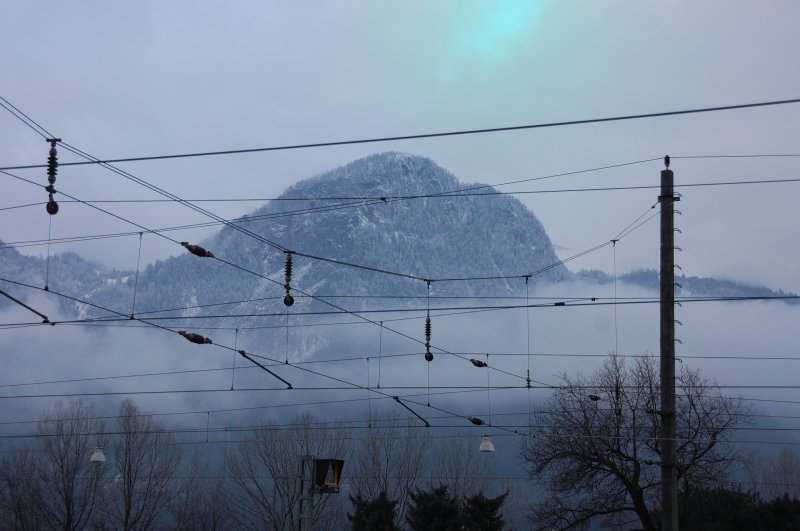 Hab mir echt lang berlegt, ob ich das Bild on stellen soll. Durch die hereinziehende und heranziehende Klte mit Schneefall innerhalb ein paar weniger Minuten entdeckte ich um den Bergrcken trkisfarbene Farbfelder tanzen. So was hatte ich noch nie gesehen. Es knnte sich um Polarlichter handeln, so ein befreundeter Naturwissenschaftler, die durch eine gnstige Konstellation der Magnetfelder hervorgerufen wurden. Die grne Frbung zeugt von Sauerstoff in einer Hhe von 80 bis 150 km. Der Bezug zur Bahn: Es kommt zu Strungen in der Versorgung und vor allem in der Frequenz des Bahnstroms. (Aufgenommen ber Brixlegg am 2. Dezember 2008).