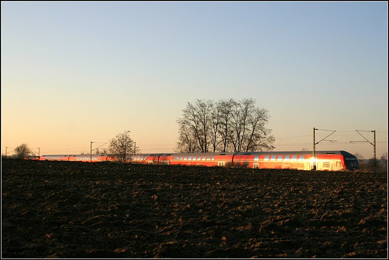 Halb im Erdboden versenkt - 

... fährt dieser Regionalexpress-Zug als leuchtend rotes Band durch die Landschaft in Richtung Aalen. 

19.02.2008 (M)