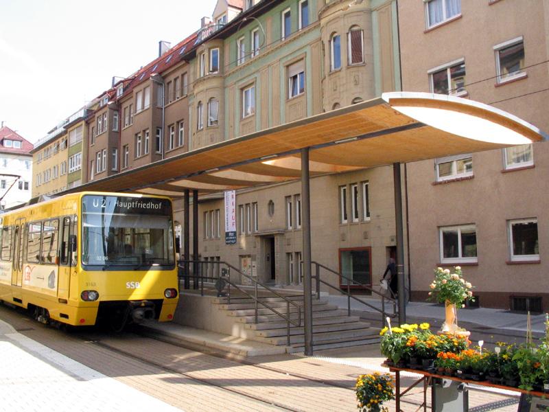 Haltestelle in enger Straße - 

Endhaltestelle Hölderlinplatz der Linie U2. Die enge Straße wurde für den Individualverkehr gesperrt, um Platz für den architektonisch besonders gestalteten Hochbahnsteig zu erhalten. 

26.05.2004 (M)