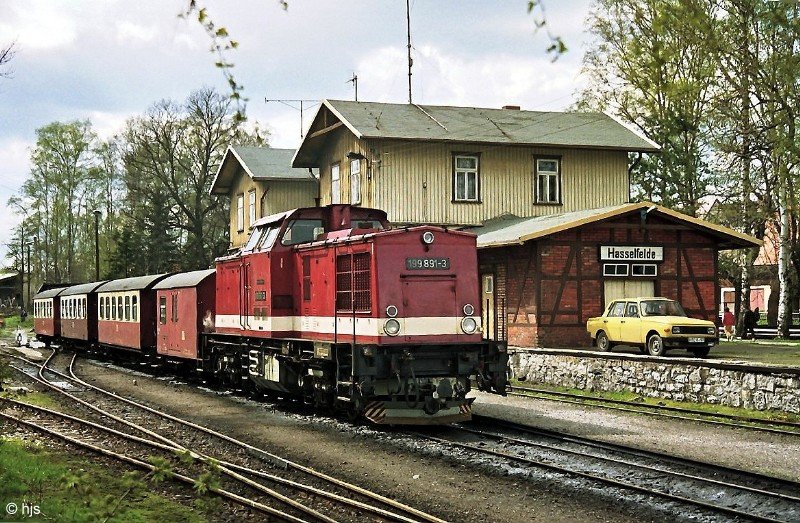  Harz-Kamel  199 891 mit P 14415 in Hasselfelde (16. Mai 1991). Der Grenunterschied zwischen Lok und Wagen wirkt geradezu grotesk!