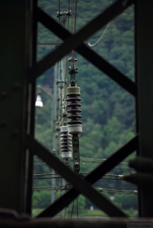 Hauptbahnromantik (Mittelrheintal). Blick durch den Masten auf die Isolatoren im Tr�gerwerk der Oberleitung. (Assmannshausen, 12. Juni 2009) 