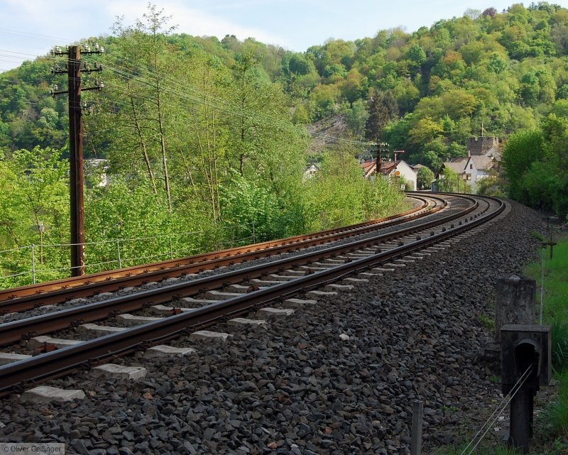 Hauptbahnromantik (XX, untere Lahntalbahn). Telegrafenmasten und Seilzüge zieren die Kurve entlang des Ortsrandes von Balduinstein, diesmal von Westen her. (25. April 2009)