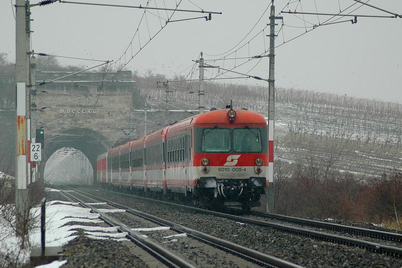 Heute (5.1.2006) hat mich aunahmsweise einmal das schlechte Wetter dazu bewegt fotografieren zu gehen. Kurz vor Wien war es sehr duster und es gab Schneeregen. 6010 005 mit dem IC 559 auf dem Weg nach Graz kurz nach Gumpodskirchen. Im Hintergrund sieht man den sogenannten  Busserltunnel . Aufgrund der Weihnachtsferien wurde der Zug heute durch zwei Schlierenwagen verstrkt.