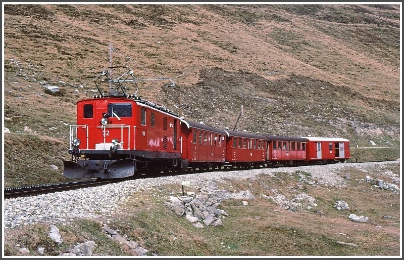 HGe 4/4 32 mit Regionalzug vom Oberalppass Richtung Andermatt noch mit offenen Platformwagen. (Archiv 11/77)