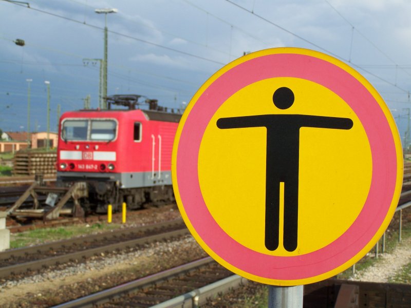 Hier bitte stehen bleiben. Das betreten der Bahnanlage ist fr Unbefugte verboten. Das soll dieses Schild ausdrcken, das Schild steht im Bahnhof Ingolstadt, im Hintergrund eine Br.143. Aufgenommen im Juni 2007.
