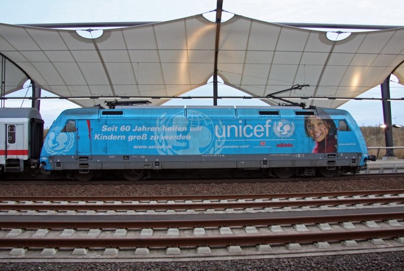 Hier brckelt nicht die Fassade sondern die Folie.  unicef -Lok 101 016-4 schiebt am Morgen des 02.10.2009 den IC 2238  Warnow  nach Warnemnde. Hier beim Halt im Bahnhof Leipzig-Flughafen.