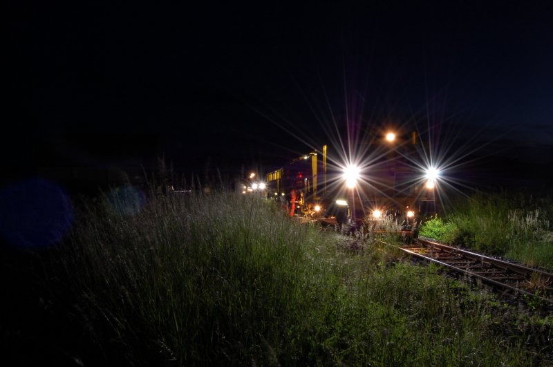Hier ist nochmal die Stopfmaschine zu sehen. Im Hintergrund sieht man noch die Lichter des  Pfluges  der die L�cher, die durch das Stopfen entstehen, wieder zumacht. Hier bei Gebenbach. (Strecke Amberg-Schanittenbach)