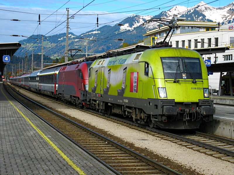 Hier der selbe Zug, aber in einem leicht gendertem Winkel fotographiert. Da kann man die lnge des ganzen Transalpin mit seinen 15 Wagen besser erkennen. 
Lg
