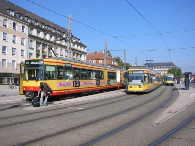 Hier sind die S- und Straenbahn-Haltestellen vor dem Hauptbahnhof Karlsruhe zu sehen. Links Stadtbahnwagen 574 auf der Linie S11 mit Ziel Ittersbach. Rechts sind zwei Niederflur-Straenbahnen vom Typ GT8-70D/N zu sehen, die im rein innerstdtischen Verkehr eingesetzt werden. Die Aufnahme entstand am 04.09.2004.