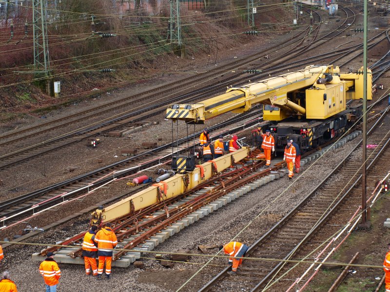 Hier wird am Westbahnhof Aachen am 29.03.2009. eine 32 to. schwere Doppelkreutzweiche  von einem Gleisbauschienenkran KRC 810T der DB Netz AG Instandsetzung cm. genau abgelegt.