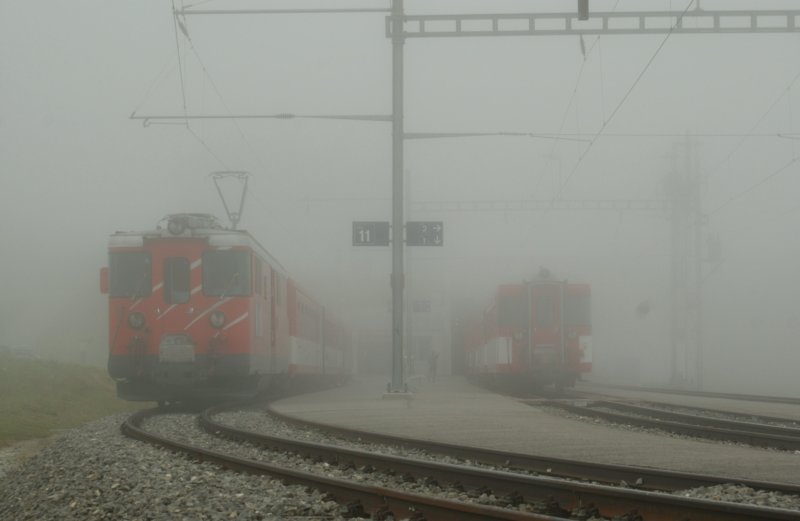 Hinter dichtem Nebel verstecken sich auf der Station Oberalppass der Regionalzug 847 nach Andermatt und der Regionalzug 844 nach Disentis. 
