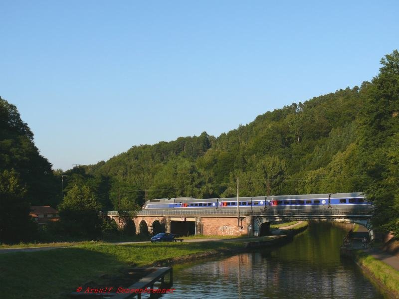 Hinter Saverne steigt die Strecke Richtung Westen und �berquert mit einer Br�ckenkonstruktion nacheinander die Zorn, die Departemenalstra�e und den Rhein-Marne-Kanal.
Eine TGV-R Einheit als Zug TGV2449 (Paris17:24-Strasbourg19:42) auf dem Weg nach Strasbourg.

04.08.2007 hinter Saverne

