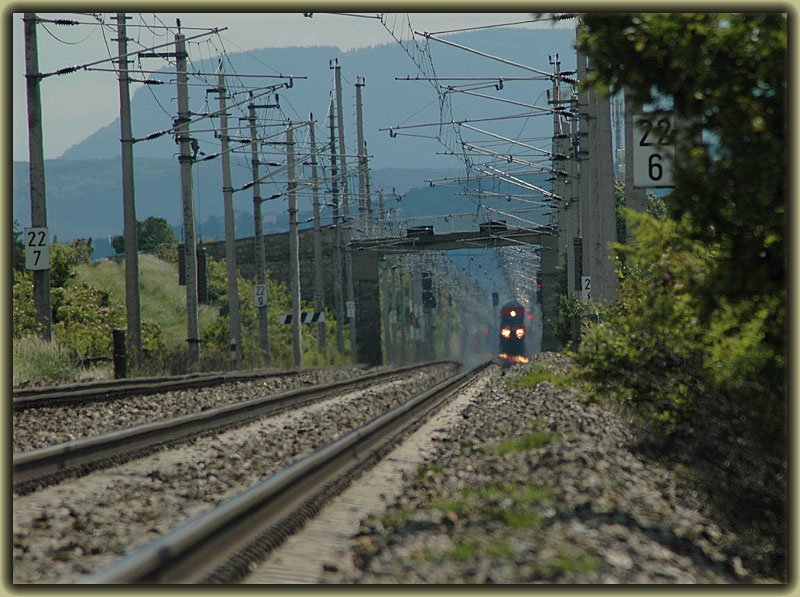 Hitzeflimmern: Eine Doppelstockgarnitur bei der Durchfahrt der Haltestelle Pfaffsttten an der Sdbahn. Ich schtze einmal, dass der Zug auf diesem Foto von mir ca. 1 Kilometer entfernt ist. Die Aufnahme entstand brigens am 10.6.2006.