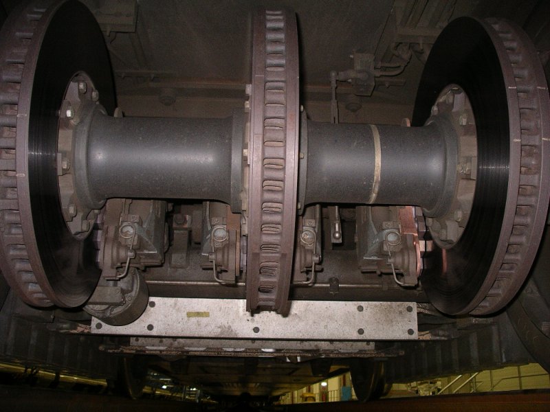 ICE3: Detailansicht auf Achse mit Scheibenbremsen und den ansonsten recht glatten Unterboden.
Die Zge werden im Werk Dortmund regelmig gewartet. Dies findet  nachts statt, da die Zge tagsber im Einsatz sind. Daher war auch die ffentliche Werksbesichtigung, bei der die Bilder entstanden, erst spt abends am 25.01.2005.

