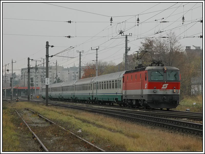 Ich habe mir lange berlegt, ob ich dieses Bild hochladen soll. Angesichts der Tatsache, dass dieser Zug in dieser Form nicht mehr existiert, habe ich mich aber dann doch dazu entschlossen. Das Bild zeigt den EC 32 „Stradivari“ gezogen von 1044 011 von Venedig nach Wien am sehr trben 19.11.06 bei der Durchfahrt in Wien Atzgersdorf-Mauer. Seit Fahrplanwechsel am 10.12.06 wird dieser Zug mit BB Waggons und einer Lokomotive der BR 1116 bespannt (lt. Plan eine der 5 GySEV Maschinen 1116 061-065)