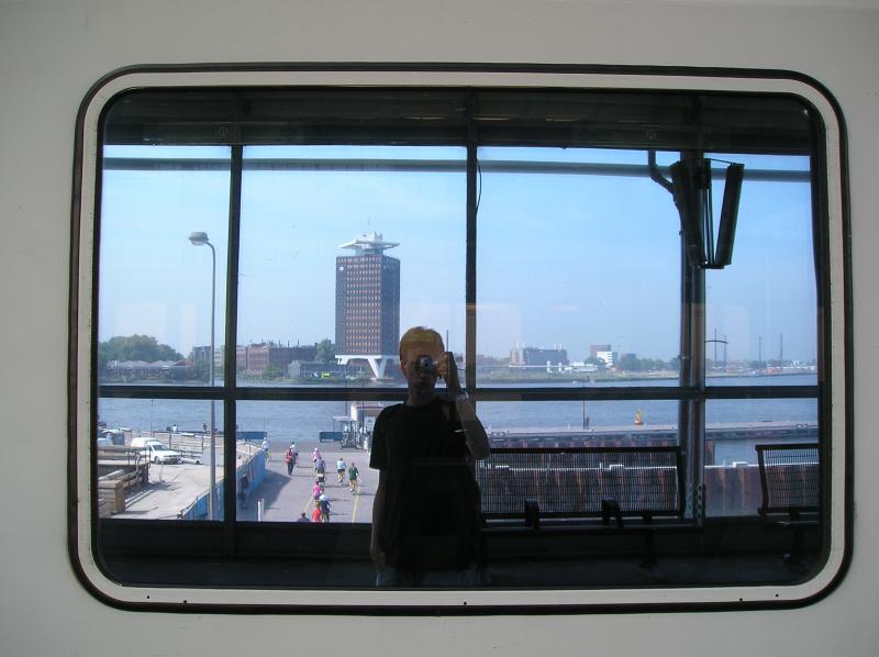 Ich liebe die Fenster eines IC. Im Hintergrund sieht man das  IJ , einem Gewsser hinter dem Amsterdam Zentralbahnhof, und einem Teil von Amsterdam-Noord. 

Amsterdam Centraal, 14.07.2005