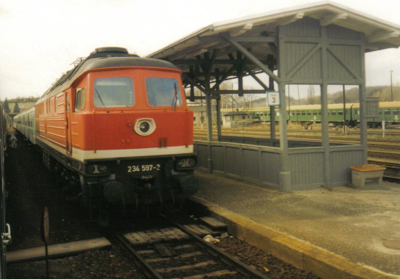 Im Bahnhof Nossen, steht 234 597-2 mit RE Leipzig-Dresden. Im Hintergrund stehen noch abgestellte Reisezugwagen der Gattung Bghwe. Bild vom 04.04.98.