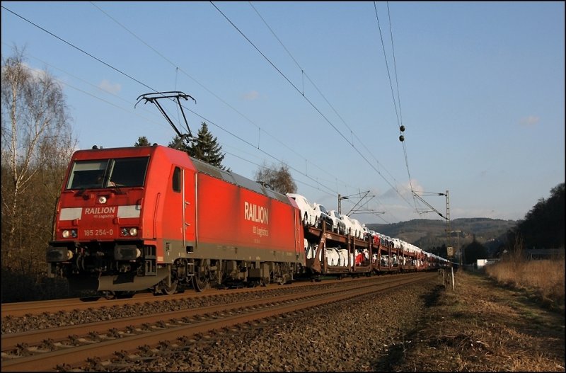 Im Blockabstand folgt 185 254 mit dem CSQ 60058(?)  AUDI-Express , Ingolstadt Nord - Emden, und fhrt im Abendlicht bei Hohenlimburg der Kste entgegen. (19.03.2009) 
