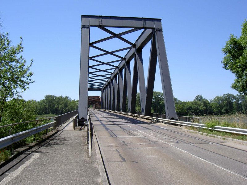 Im eigenen Archiv gekramt: 19. Juni 2005 am Rheinbergang Wintersdorf bei Rastatt. Die Brcke fhrte einst zweigleisig Schienen von Deutschland nach Frankreich. Die Schienen sind auf der Brcke jedoch zugeteert und existieren auch nur noch auf der Brcke. Vor und nach der Brcke sind die Gleise teilweise rausgerissen oder komplett berteert. Ein Stck weiter stlich wird das Gleis noch als Verbindung zwischen dem Daimler Werk Rastatt und den Bahnhof Rastatt aktiv genutzt. 
