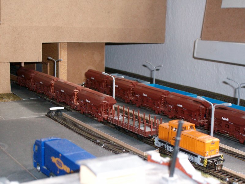 Im Getreidezwischenlager rangiert eine BR 106 der DR.Es werden immer 4 Wagen zur Be.-bzw Entladung unter das Dach geschoben.Damit das Dach nicht so eingerut wird,wird noch ein Schutzwagen dazwischengekoppelt.