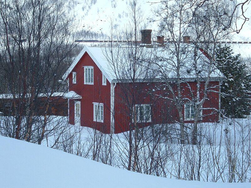 Im Hintergrund fhrt eine IORE-Doppellok mit leeren Erzzug zur 13 km entfernten Riksgrnsen, der Zug kam leider nicht durch den Bahnhof Katterat, er benutzte die neue Strecke. Nur bei Kreuzung von 2 Erzzgen fhrt einer die alte Strecke, die alten Ausweichgleise waren fr die 52-Wagen-Zge zu kurz, die Weichen sind inzwischen abgebaut, aufgenommen am 19.03.2006.