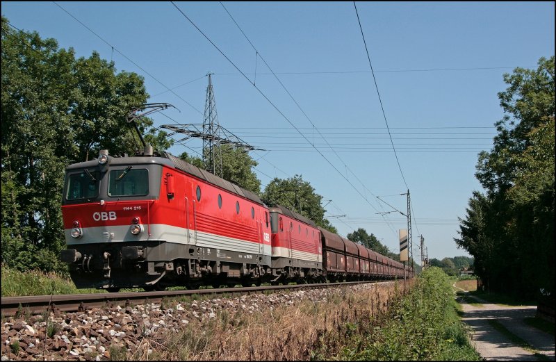 Im der Morgensonne des 11.07.2008 sind die Innsbrucker 1144 215 (9181 1144 215-x) und einer Schwesterlok mit einem leeren Ganzzug auf dem Rckweg nach Tirol.