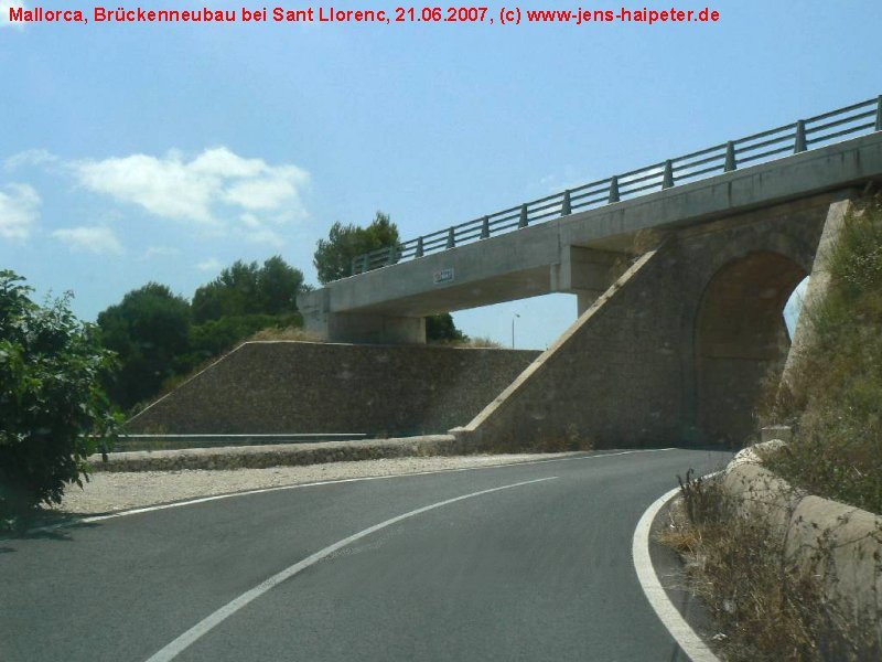 Im Zuge des Neubaus der Umgehungsstrae von Sant Llorenc de Cardasar (C-715) wurden zwei Brcken neu errichtet. Die hier abgebildete befindet sich ca. 0,5 km vom Bahnhof entfernt in Richtung Art. Der Bau ist 2002/2003 erfolgt. Interessanter Weise wurde die alte Steinbogenbrcke gelassen, wo sie ist und eine vollkommen neue Betonbrcke darber gebaut. Allerdings sind an dieser Stelle noch keine Gleise in Sicht. Foto: 21.06.2007
