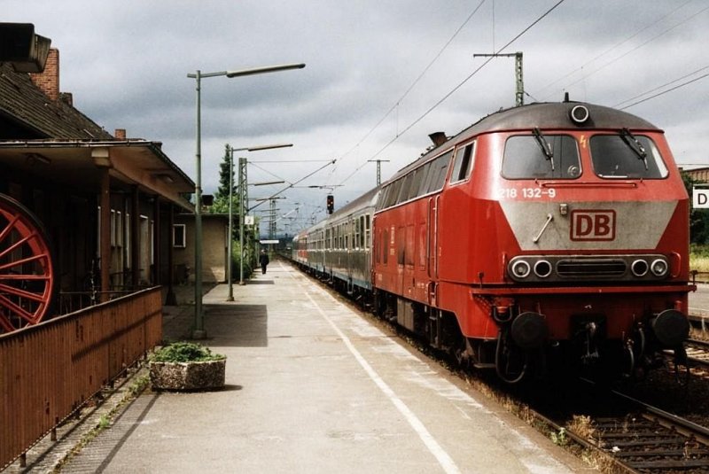 In 2001 gab es noch sehr bunte Zge in Deutschland. Hier ist die orientrote 218 132-9 mit drie verschiedene wagens (u.a. Silberlinge) als RE 12055 (RE 17 Sauerland-Express) Hagen Hbf-Warburg unterwegs auf Bahnhof Warburg am 14-7-2001. Bild und scan: Date Jan de Vries.