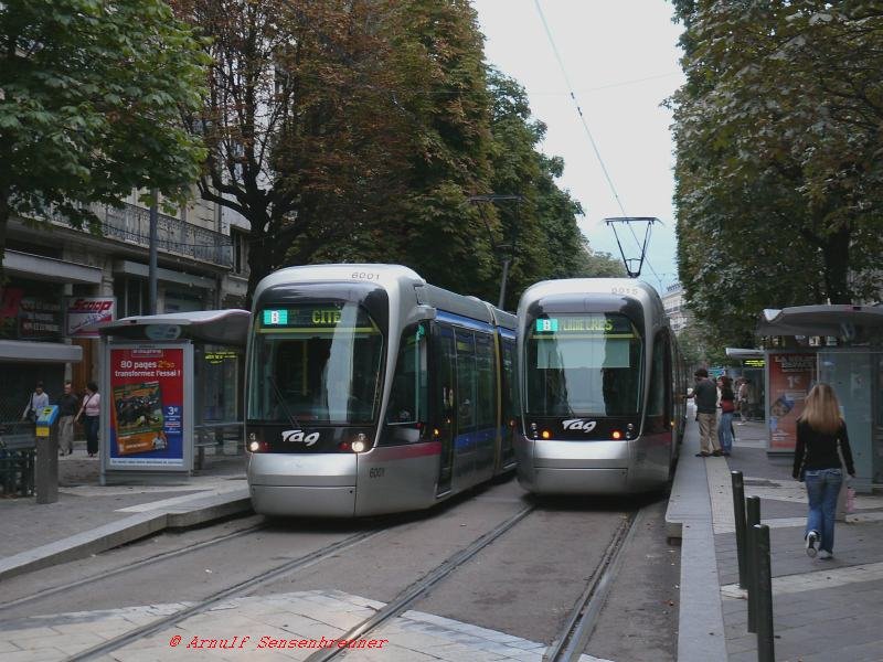 In Grenoble auf der Avenue Alsace-Lorraine sind hier zwei der neueren Citadis-Bahnen unterwegs: Tram 6001 auf Linie B nach Cit und Tram 6015 auf Linie B nach Plaine-Eres.
Auch in Grenoble werden seit 2005 35 Niederflurstraenbahnen vom Typ Alstom-Citadis402 eingesetzt (Nummern 6001-6035).
Die Kopfform ist allerdings Geschmackssache. Sie wirkt auf mich unhomogen zur restlichen Bahn.
29.08.2007 Grenoble
