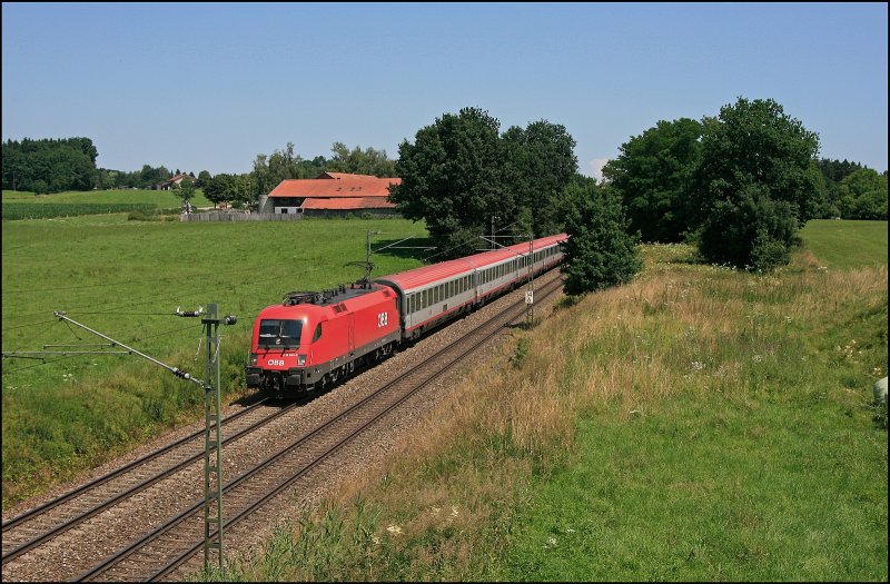In der Mittagshitze des 11.07.2008 bringt die sehr saubere 1116 049 den EC 114  WRTHERSEE , Klagenfurt Hbf - Dortmund Hbf, bei Bad Endorf nach Mnchen.
