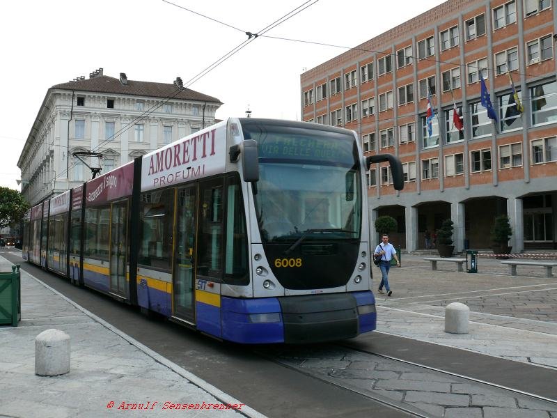 In Turin an der Piazza-Castello fhrt GTT Tram-6008 auf der Linie 4 Richtung Falchera.
Es handelt sich hier um eine 7-teilige Niederflurbahn des Typs Alstom-Cityway mit 8 Achsen. Bemerkenswert das Schuhschachteldesign.
30.08.2007 Torino