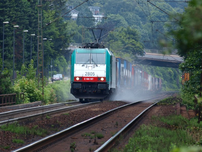 In einer Wolke aus Sand kommt E 186 197  mit einem Containerzug  von Aachen West mit Vollgas die Steigung zum Gemmenicher Tunnel rauf. Auf dem Bild kann man gut erkennen wie steil die Strecke ist. Die Brcke im Hintergrund ist die Halifaxstrasse.