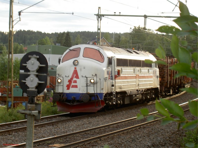 Inlandsgods TMY 1132 vor einem Holzzug auf der Strecke von nge nach Sundsvall am 17.07.2006 um ca. 22:30 Uhr (Abenddmmerung) in Stde(Medelpad).
Diese Firma ist 2007 Konkurs gegangen.
