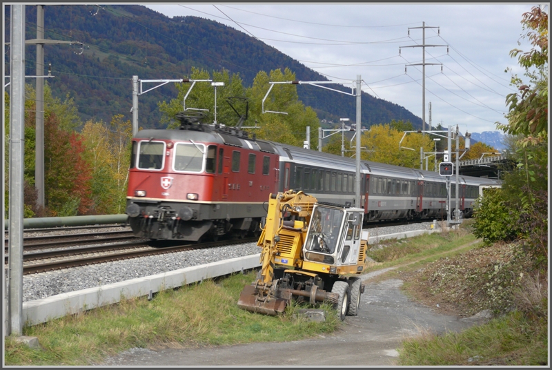 IR1765 mit Re 4/4 II 11304 passiert bei Zizers einen schienengngigen Bagger, der nebenan fr die Linienverlegung der RhB gebraucht wird. (25.10.2009)