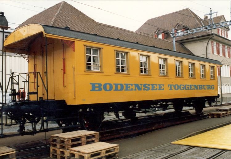 Jasswagen Gelb der ex Bodensee Toggenburg Bahn anlsslich der TV-Sendug Mittwochsjass in Tuffelen im Aug.1987 .Wagen auf Rollschemel der BTI Bahn 
