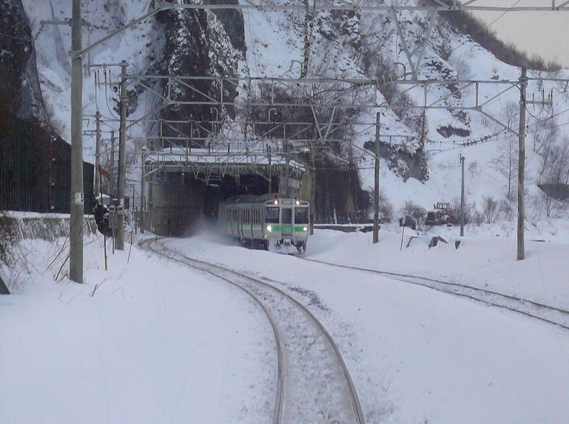 JR Serie 721: Ein Zug kommt auf der wilden Küstenstrecke zwischen Sapporo und Otaru gerade aus dem Tunnel. Bei Asari, 19.Februar 2009. S-BAHN SAPPORO 