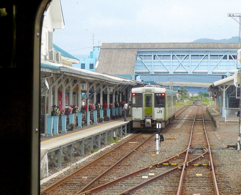 KIHA 100: KIHA 100-27 mit einem weiteren Triebwagen als Zweiwagenzug abfahrbereit in Miyako. Man beachte den Blumenschmuck am Bahnhof. 23.August 2008.