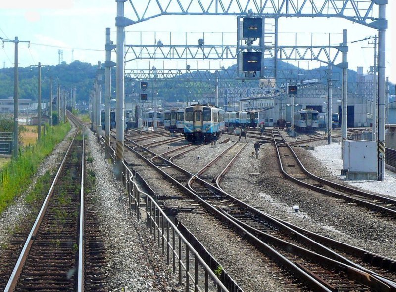 KIHA 32: In der Unterhaltsanlage der Stadt Kôchi auf der Südseite der Insel Shikoku stehen neben anderen Triebwagen auch viele KIHA 32, zuvorderst die KIHA 32 19 (mit eckigen Scheinwerfern). Tosa Ikku, 21.September 2009. 