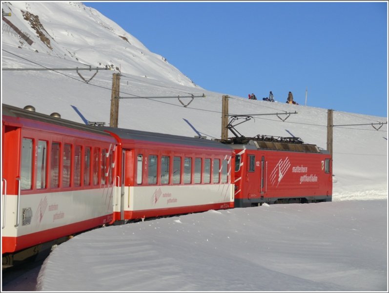 Kurz vor Erreichen der Oberalppasshhe begegnet die HGe 4/4 102 ein paar Snowboardern. (10.01.2009)