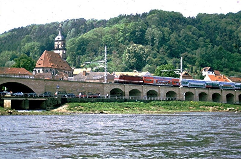 Kurz vor Knigstein/Elbe scheucht eine 143 noch in alter Lackierung ihre S-Bahn-Garnitur in Richtung Bad Schandau. April 1999