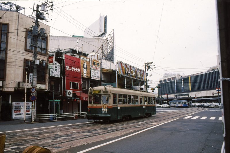 Kyoto Strassenbahn / Hiroshima Strassenbahn. Die 1915 (Baujahr 1957, Umbau 1970) fuhr bis zur Betriebseinstellung 1978 in Kyoto. Jetzt sehen wir sie in Hiroshima vor dem dortigen Hauptbahnhof (im Hintergrund), 12.Oktober 1996.
