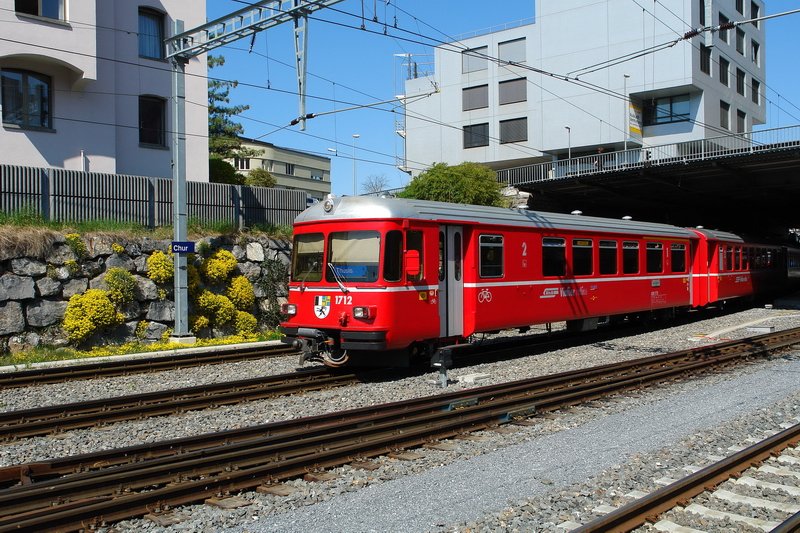 Langsam verlsst der Regionalzug der RhB, mit dem Steuerwagen 1712, den Bahnhof in Richtung Thusis. Einen schnen Kontrast zum Rot des Zuges bildet das gelbe Steinkraut an den Felssteinen. 12.4.2007