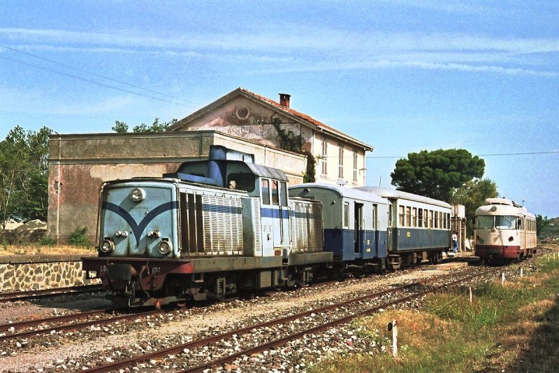 LDe 607 trifft mit ihrem Sonderzug in Tresnuraghes den planmigen Personenzug, Triebwagen ADe 01 (12. September 1989). Tresnuraghes war damals Endpunkt der Strecke von Macomer in Richtung Westen. Die weitere Strecke nach Bosa war seit 1981 stillgelegt, wurde aber 1995 reaktiviert. Heute verkehren zwischen Macomer und Bosa nur mehr Touristik-Zge.