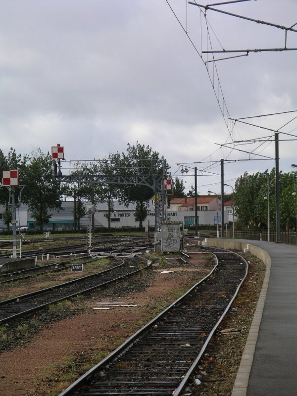 Les Sables d´Olonne Bahnhof,

einsame ber 100km vom elektrifizierten Netz der SNCF entfernte Oberleitung am Gleis 1. 
Hierher fuhren bis 2004 zeitweise von Dieselloks gezogene TGV, um diesen Badeort am Atlantik ohne Umsteigen direkt anzuschlieen. 
Um whrend der Standzeiten die Bordversorgung des TGV zu ermglichen, wurde Gleis 1 mit einer Oberleitung versehen. Ob der Oberbau so vllig TGV geeignet war, wei ich allerdings nicht. Ansonsten war hier alles noch mechanisch, was man an den Signalen im Hintergrund sehen kann. Ein TGV kam mir allerdings leider nicht vor die Linse.

13.09.2004