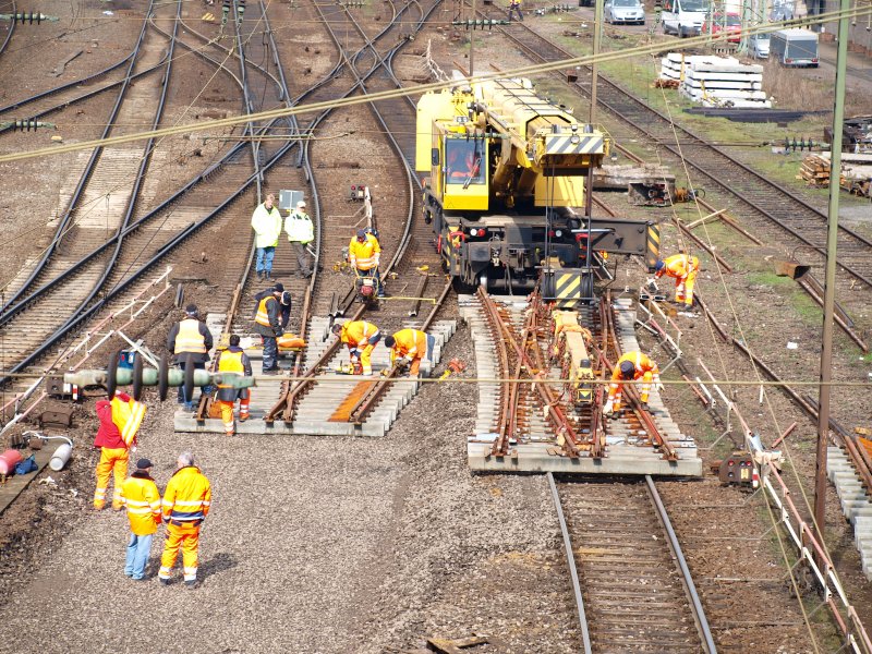 Letzte Vorbereitungen f�r den Einbau einer Doppelkreutzweiche.An dem  Gleisbauschienenkran KRC 810T wird nur noch die St�tze eingefahren, dann f�hrt der Kran mit 32to. Last am Hacken auf das schon eingesetzte neue Gleis und legt die Weiche ab.