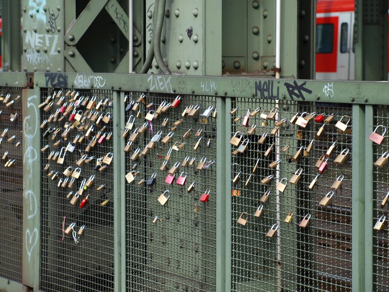 Liebesschlsser. Sie hngen inzwischen zu hunderten an der Hohenzollernbrcke. Hier hngen Paare ein Schloss in das Gitter welches den Fuweg ber die Brcke von den Gleisen trennt, schwren sich ewige Treue und werfen dann den Schlssel in den Rhein.